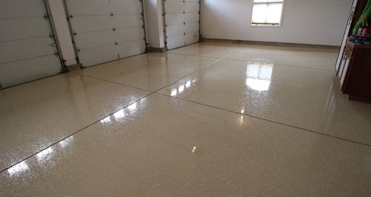 The image shows an empty garage floor epoxy flooring on it.
