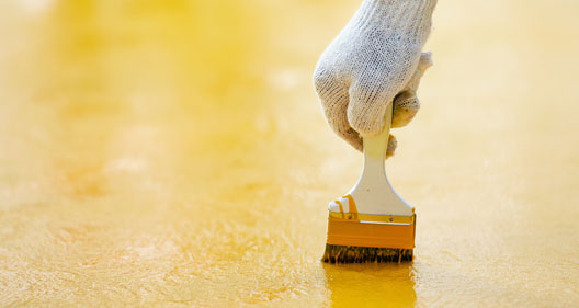 This image shows someone applying epoxy paint ion a floor.