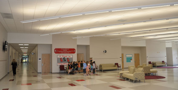 This image shows the inside of a school with kids standing near the door.