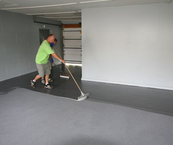This image shows 2 men applying epoxy paint on the floor.