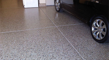 The image shows a garage floor with a car on it.